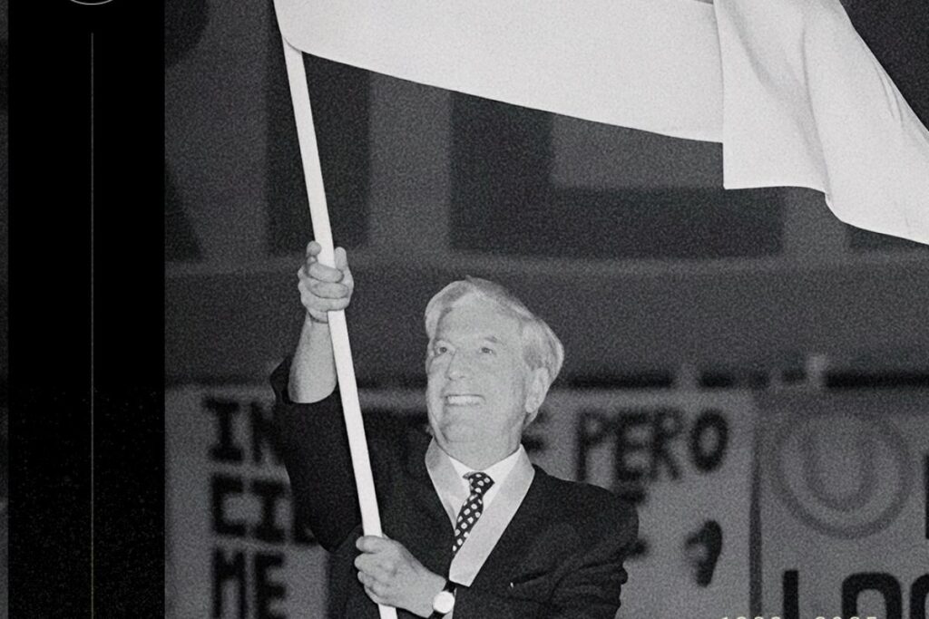 Mario Vargas Llosa con una bandera de Universitario de Deportes de Perú.