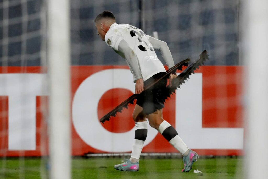Lucas Cepeda de Colo-Colo recoge objetos lanzados por aficionados en un partido de la fase de grupos de la Copa Libertadores entre Colo-Colo y Fortaleza en el estadio Monumental en Santiago.