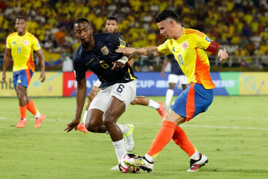 Willian Pacho (i) marca a James Rodríguez en un partido de las eliminatorias sudamericanas al Mundial 2026.