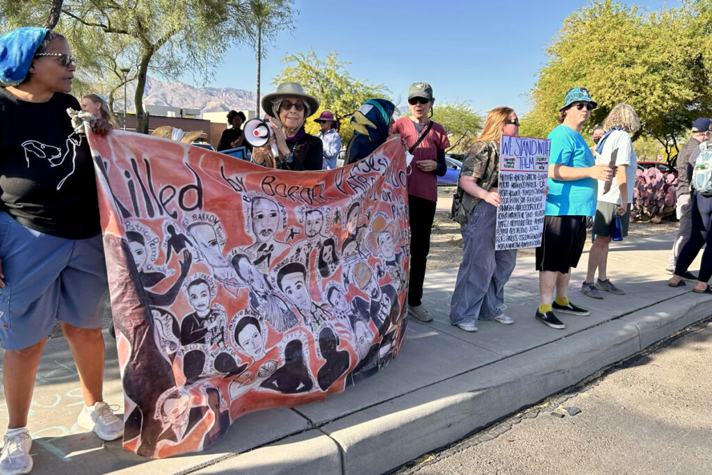 Personas sostienen carteles y banderas durante una manifestación en contra de las deportaciones, en Tucson (Estados Unidos). Foto: EFE