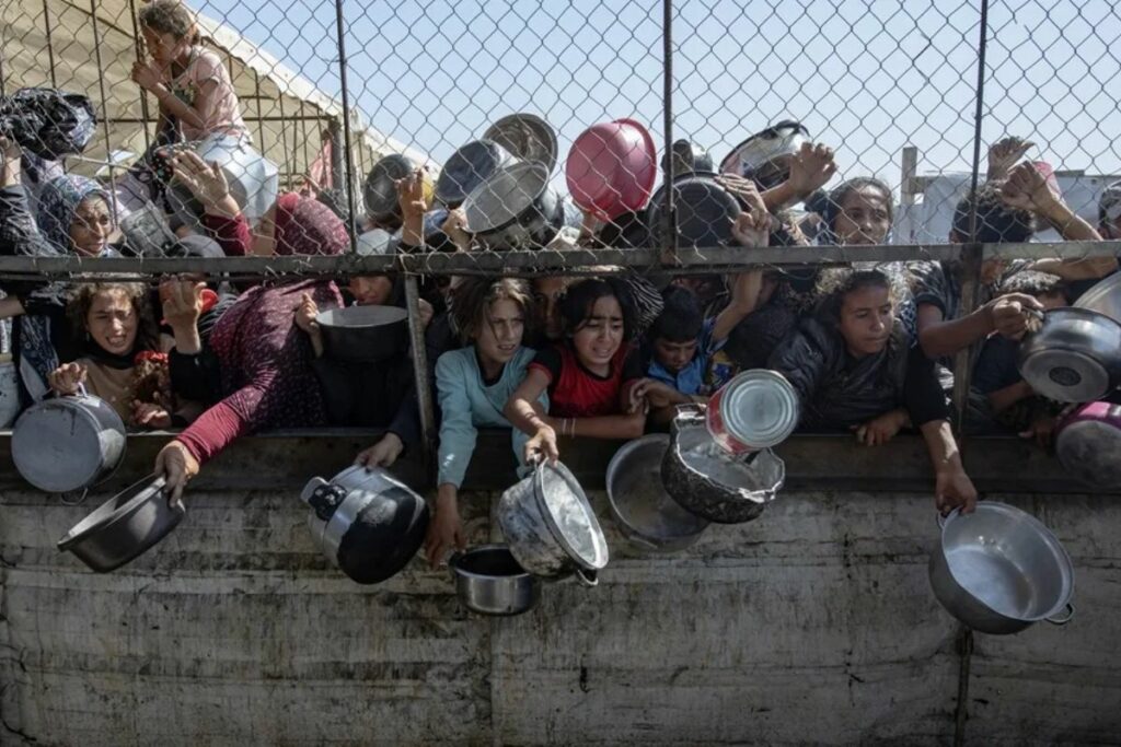 Niños palestinos se agolpan para recibir una ración de comida en Jan Yunis, al sur de la Franja de Gaza, este 30 de mayo. Foto: EFE