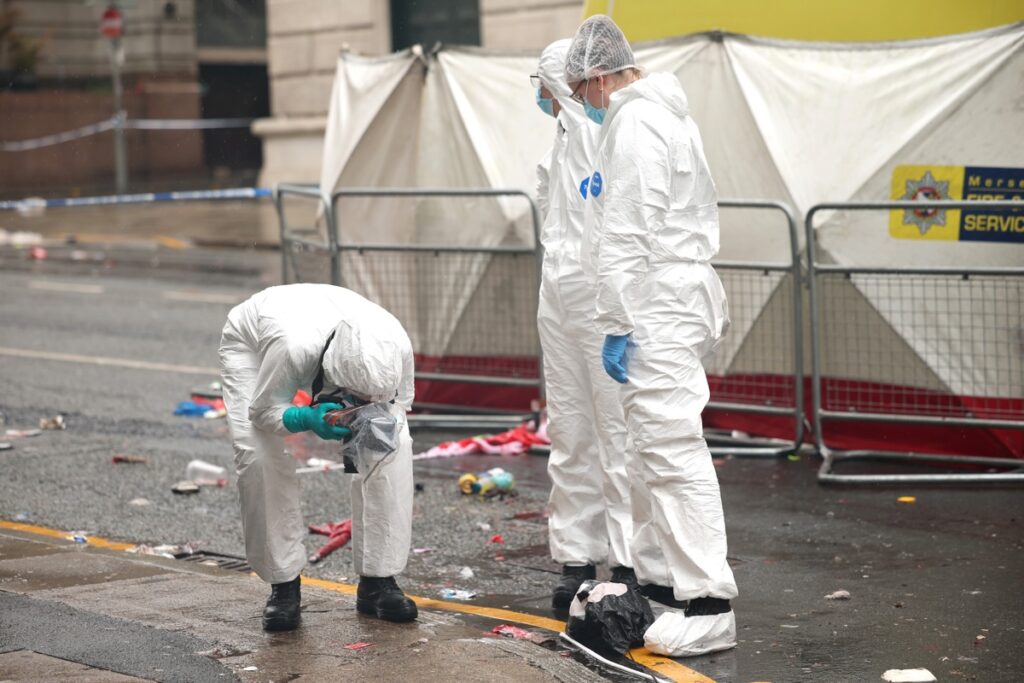 Oficiales forenses trabajan en la escena donde un automóvil chocó con personas durante el desfile del trofeo del Liverpool FC en el centro de la ciudad de Liverpool, Gran Bretaña, el 27 de mayo de 2025.