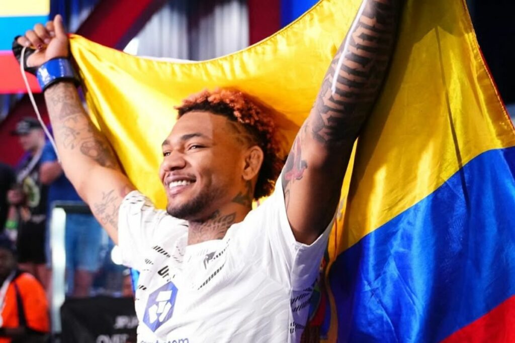 Michael Morales festejando otro triunfo de la UFC con la bandera de Ecuador.