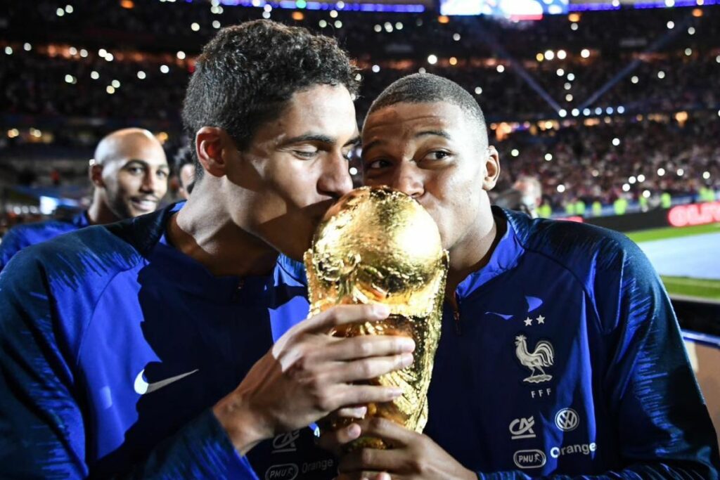 Raphaël Varane (i) y Kylian Mbappé con el trofeo de la Copa del Mundo ganada en 2018 con Francia.