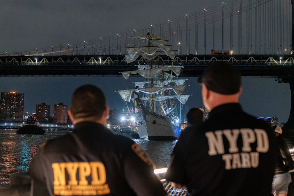 Integrantes del departamento de Policía de Nueva York observan el buque escuela mexicano Cuauhtémoc junto al puente de Brooklyn.