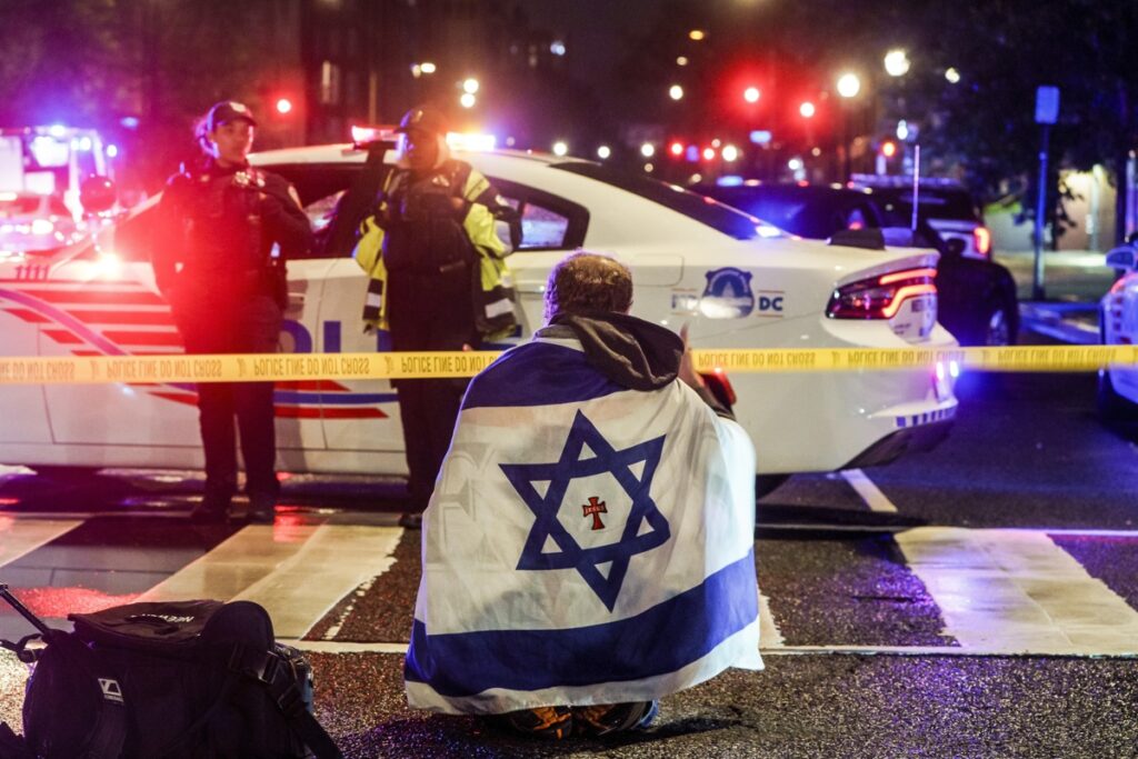 Un hombre con una bandera israelí cerca del lugar donde dos personas fueron asesinadas a tiros cerca del Museo Judío Capital en Washington.