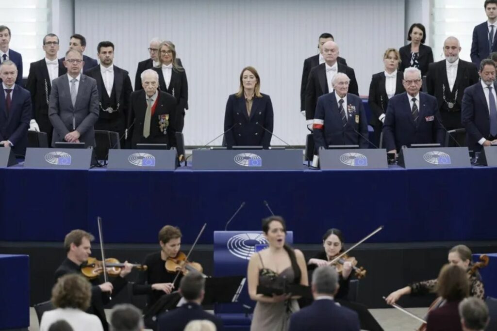 La presidenta del Parlamento Europeo, Roberta Metsola, junto a tres veteranos de guerrar durante la conmemoración del 80º.