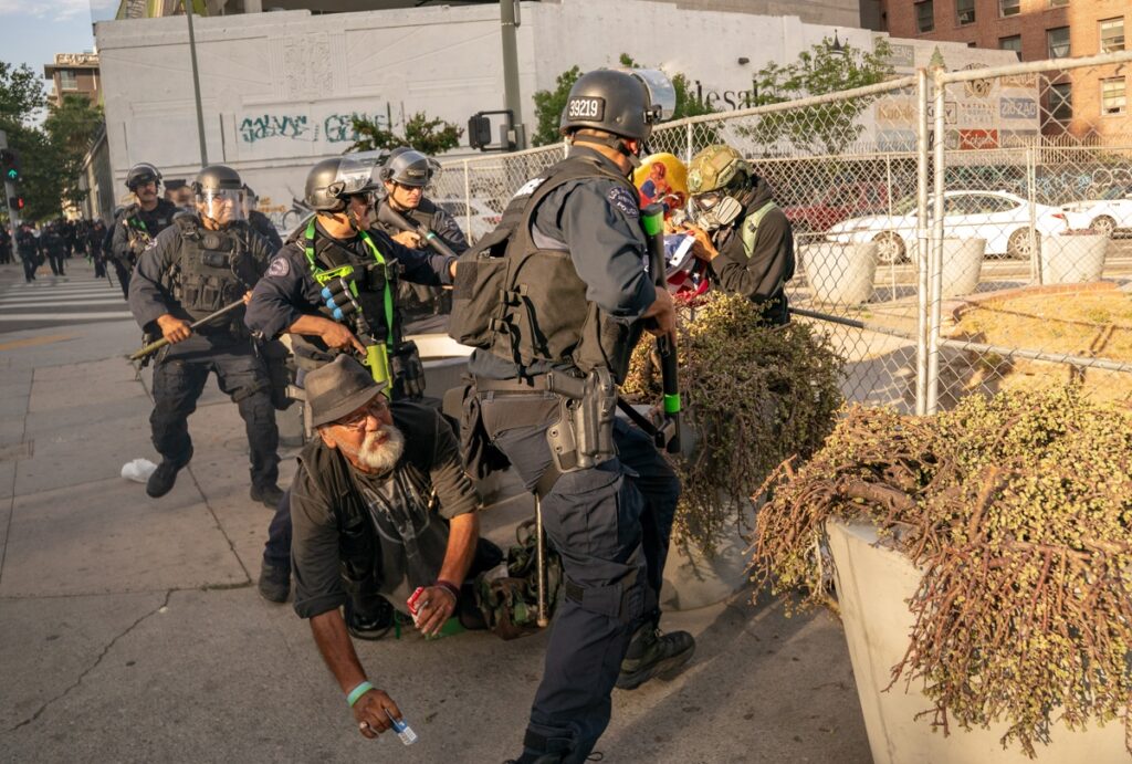 Un transeúnte es empujado al suelo durante una protesta del "Día sin Reyes" en Los Ángeles, California, EE. UU., el 14 de junio de 2025. Foto: EFE