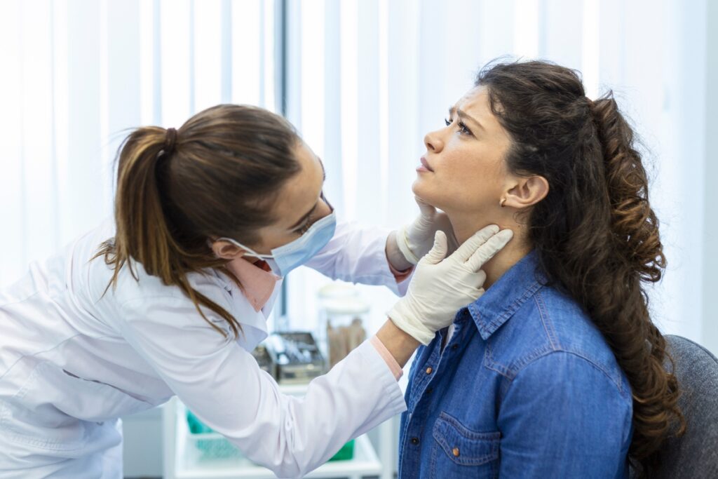 Endocrinóloga revisa la glándula tiroidea de una paciente. Foto: Freepik