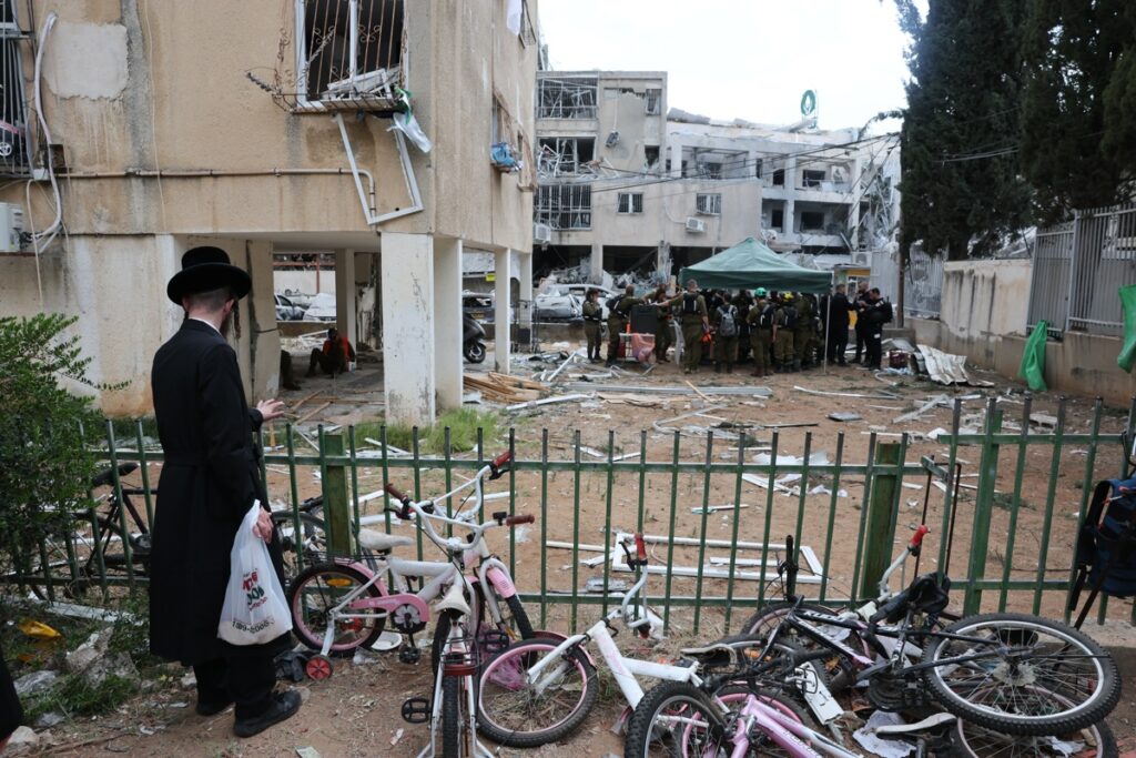 Un hombre judío ultraortodoxo se encuentra cerca de una escuela de niñas judías ortodoxas dañada después de que misiles balísticos iraníes impactaran Bnei Brak, Israel.