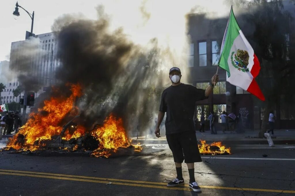 Un manifestante ondea una bandera de México durante una protesta contra las redadas de Inmigración ordenadas por el presidente Donald Trump.