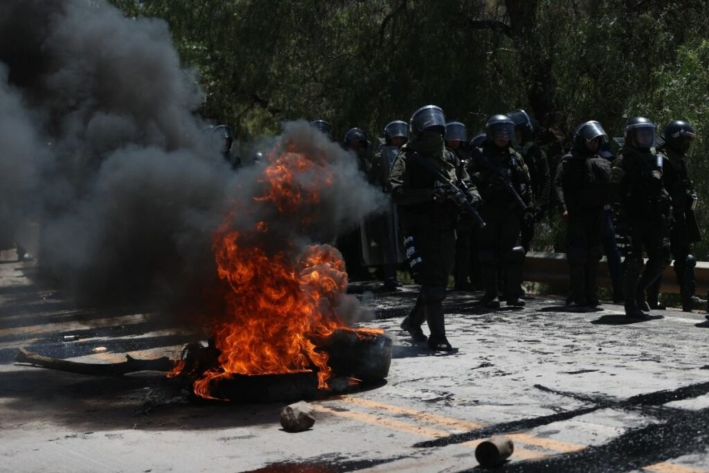 Integrantes de la Policía Boliviana caminan por una vía bloqueada en Parotani, en Bolivia