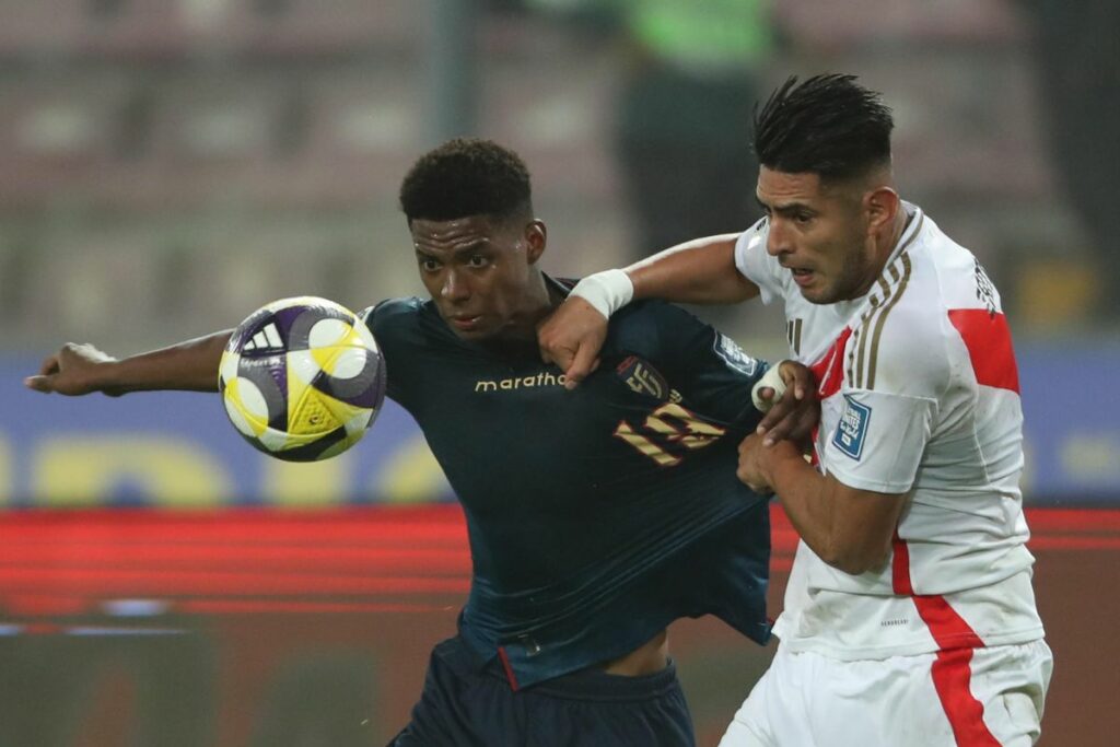 Carlos Zambrano (d) disputa un balón con Nilson Angulo en un partido por las eliminatorias sudamericanas para el Mundial 2026 entre las selecciones de Perú y Ecuador en el Estadio Nacional.