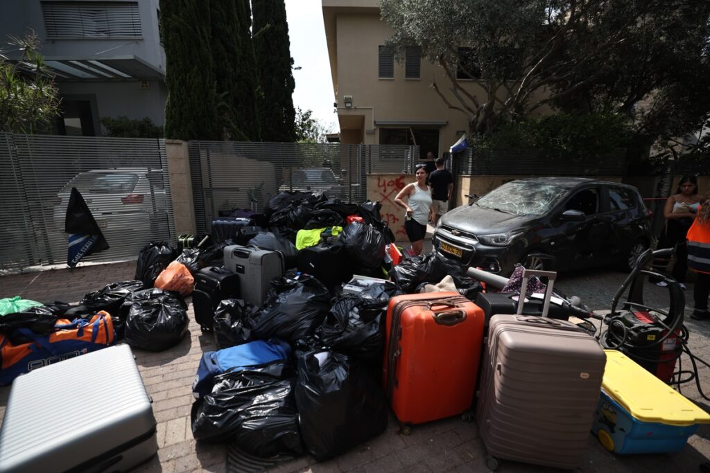 Residentes recogen sus pertenencias tras un ataque con misiles iraníes en Ness Ziona, al sur de Tel Aviv, Israel. Foto: EFE