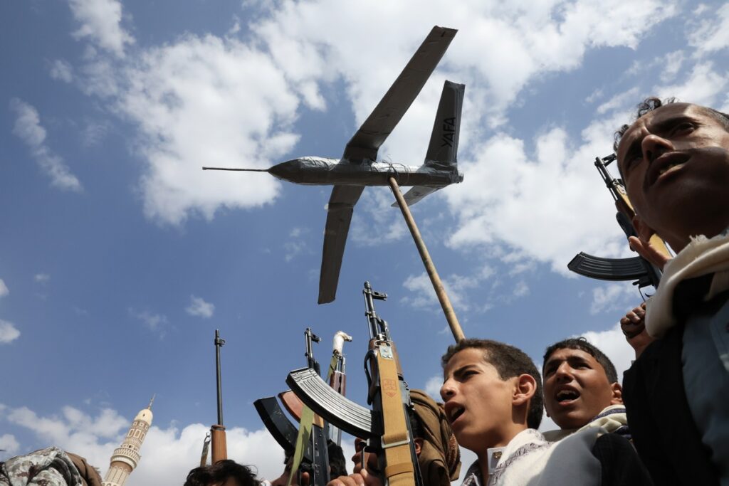 Partidarios hutíes gritan consignas y levantan un dron simulado durante una protesta contra Estados Unidos e Israel, en Saná, Yemen.