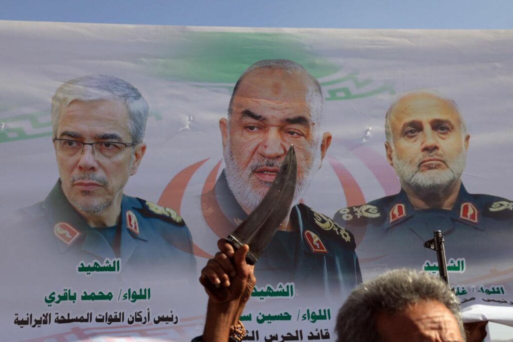 Partidarios de los Houthi sostienen una pancarta que muestra a los funcionarios iraníes.