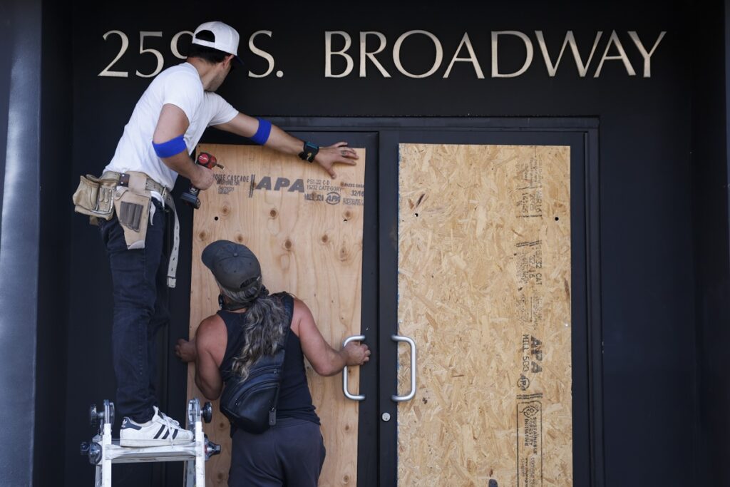 Personas tapan la fachada de una tienda mientras continúan las protestas en Los Ángeles, California, EE. UU..