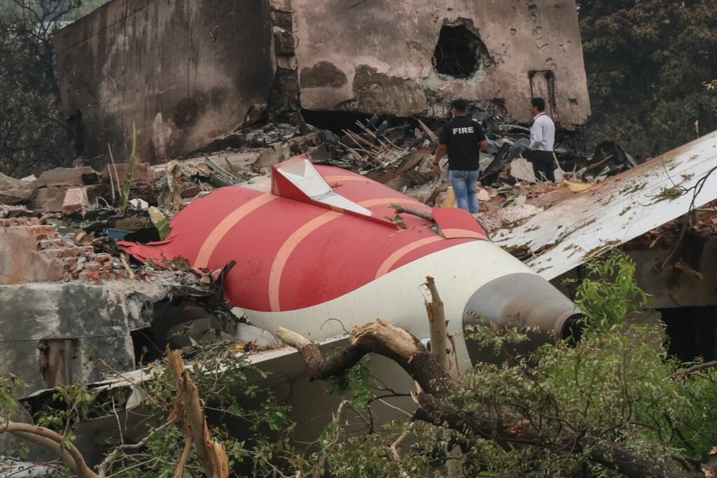 Los oficiales observan los restos del avión siniestrado en la ciudad de Ahmedabad, Gujarat, India este viernes.