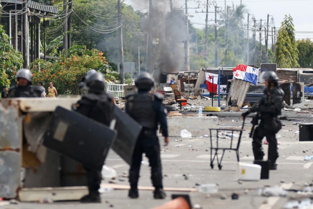 Integrantes de la Unidad de Control de Multitudes (UCM) observan un bloqueo en la jornada de protestas, en Changuinola, Bocas del Toro, (Panamá).