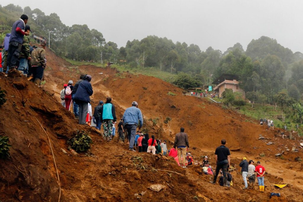 Personas observan la zona afectada por una riada este martes, en Bello Antioquia (Colombia).