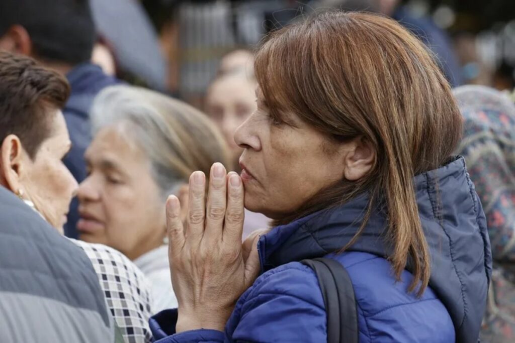 Una mujer reza por la salud de Miguel Uribe, frente a la Clínica Fundación Santa Fe de Bogotá (Colombia). Foto: EFE
