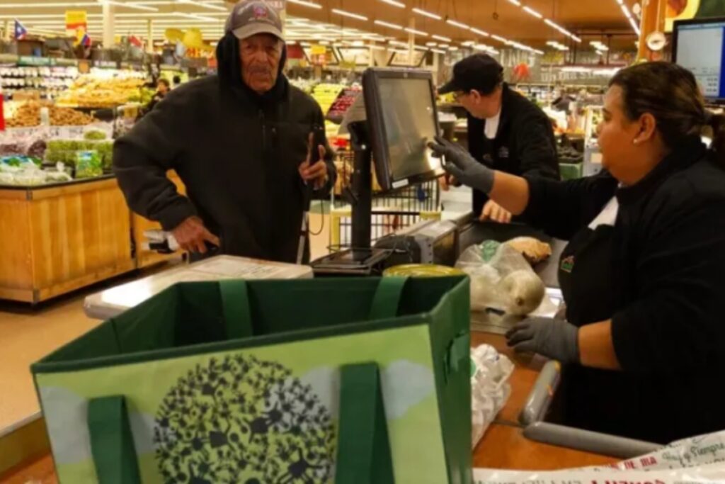 Una cajera del supermercado Northgate González Market atiende a un cliente. Foto: EFE