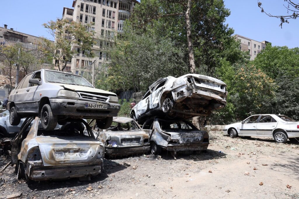 Autos dañados en un área de estacionamiento afuera de la prisión de Evin después de los recientes ataques aéreos israelíes, en Teherán, Irán.