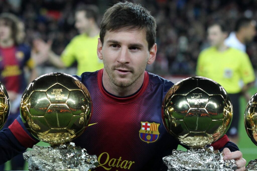 Lionel Messi posando con cuatro Balones de Oro en su etapa en el FC Barcelona.