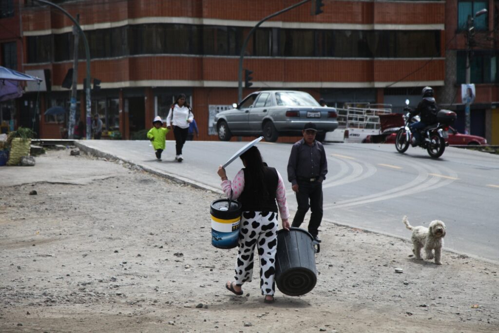 Moradora de Caupichu, sur de Quito, lleva baldes vacíos para abastecerse de agua.