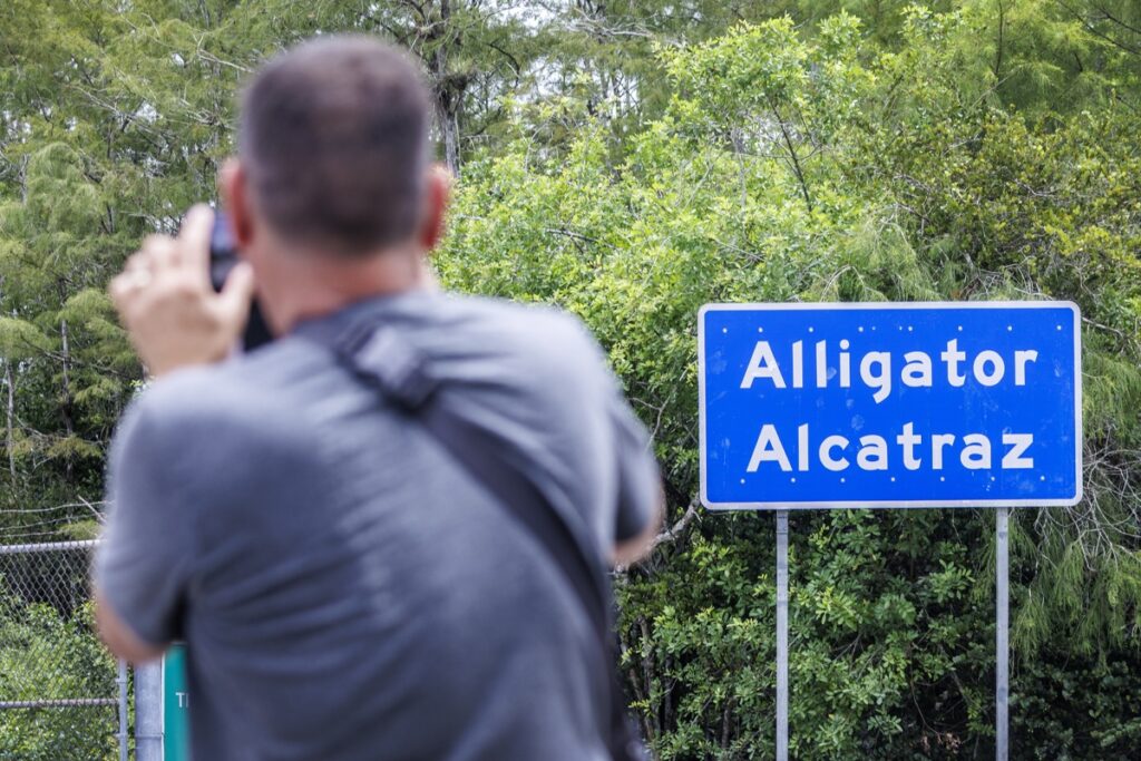 Un hombre fotografía la entrada del nuevo centro de detención Alligator Alcatraz en Ochopee, Florida.