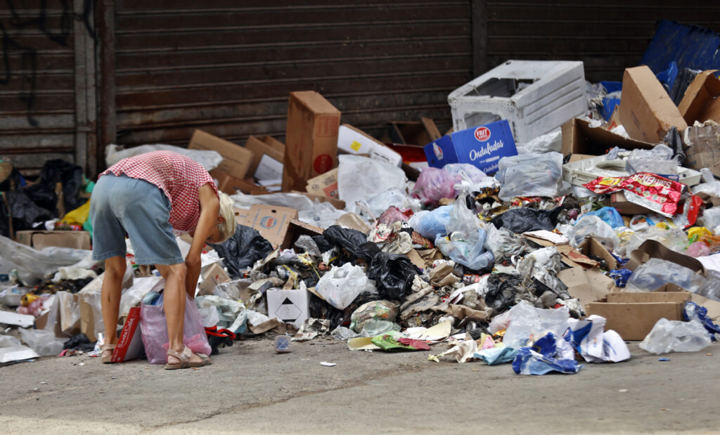 Una persona busca cosas en la basura, en una calle de La Habana (Cuba). José Fernández se seca el sudor de la cara para bucear en un contenedor desbordado de basura en el céntrico bulevar de La Habana.