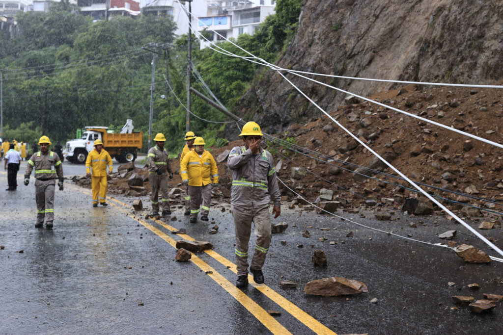 Integrantes de la Comisión Federal de Electricidad trabajan en la zona de un derrumbe provocado por las intensas lluvias este lunes, en Acapulco (México).
