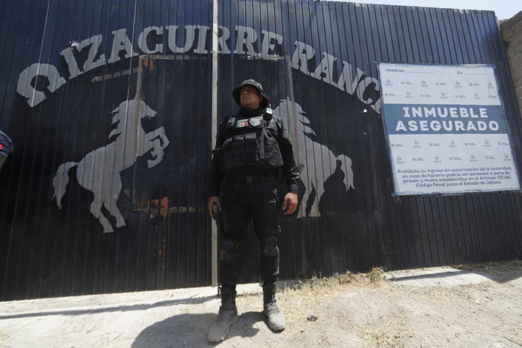 Fotografía de archivo del 20 de marzo de 2025 de un integrante de la fiscalía estatal resguardando la entrada al Rancho Izaguirre.