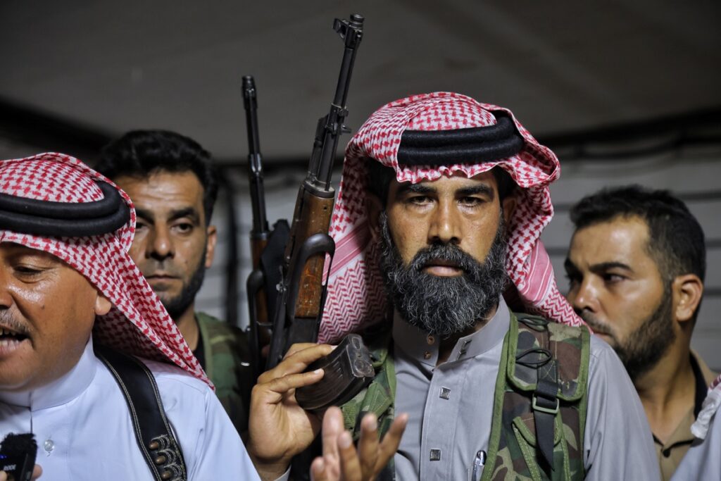 Un grupo de hombres armados se reunió dentro de la sede del Consejo de Tribus y Clanes Sirios en Idlib, Siria.