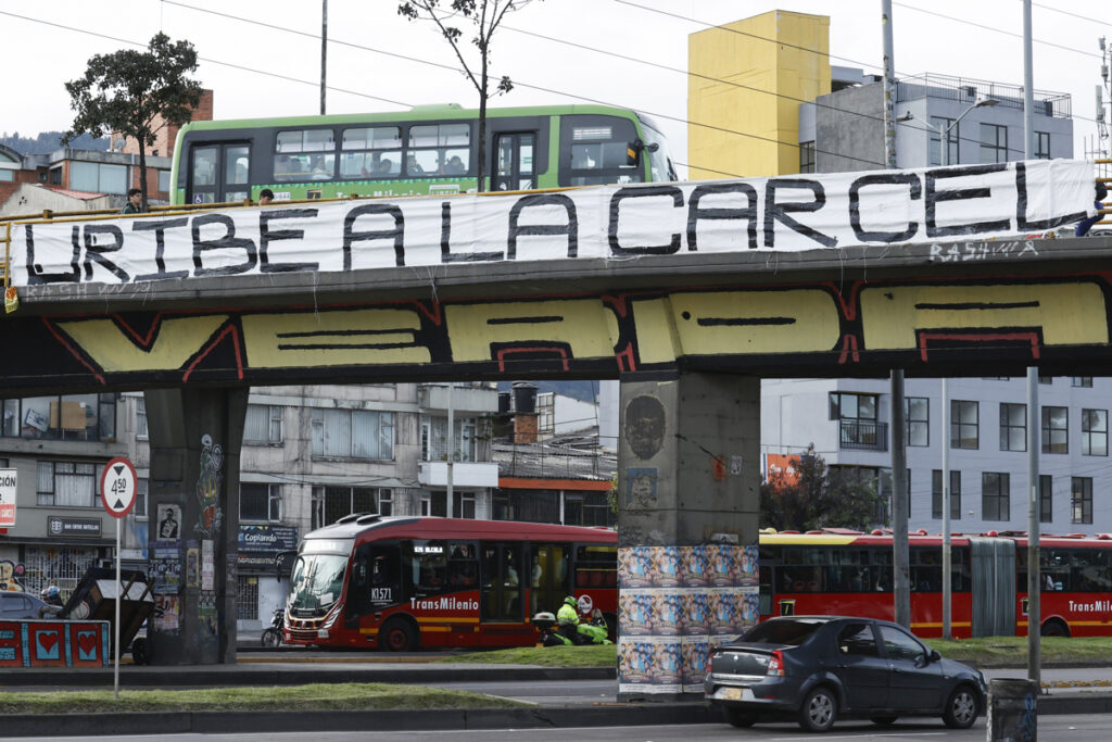 Fotografía que muestra una cartel colgado en un puente peatonal en contra del expresidente Álvaro Uribe este lunes, en Bogotá (Colombia).