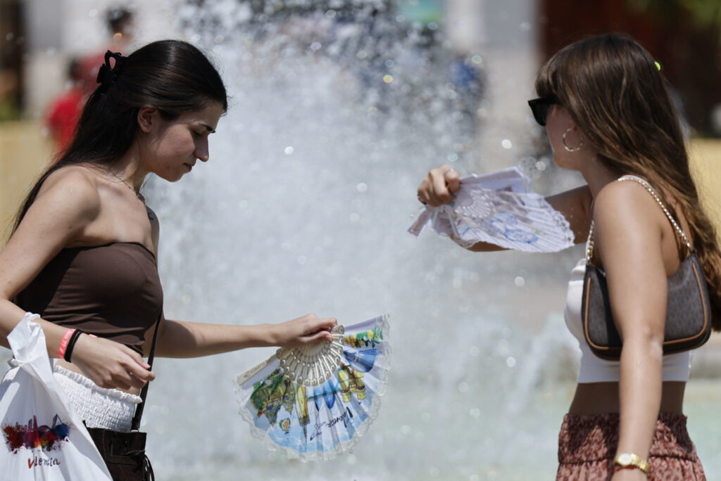 Dos mujeres se refrescan este martes en el centro de Valencia.