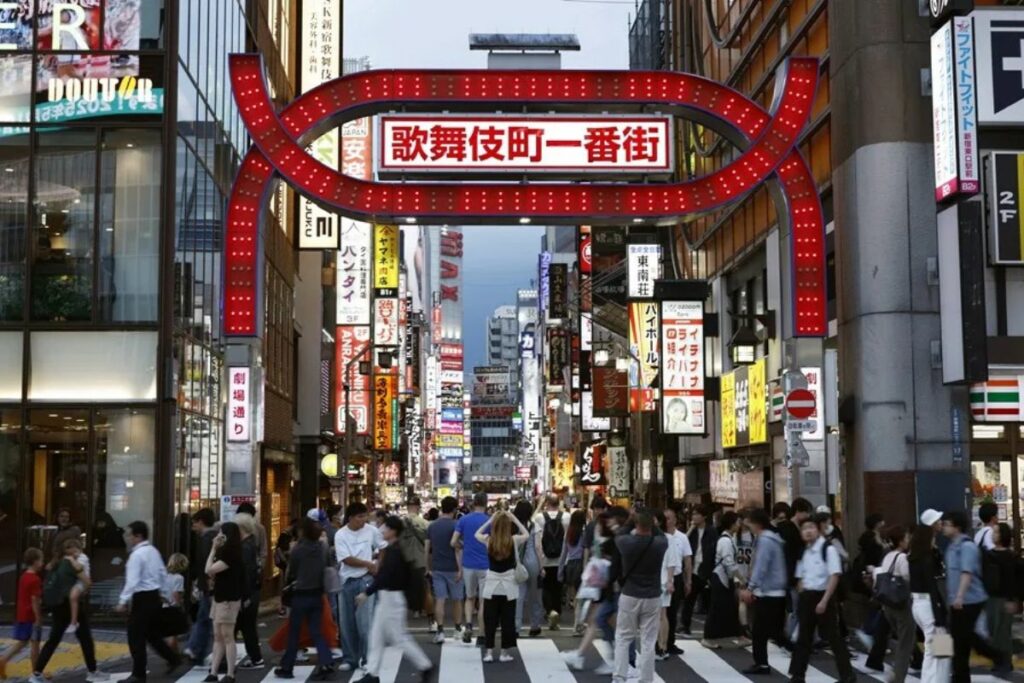 Personas pasan frente a la entrada de Kabukicho, el barrio rojo de Tokio, en Shinjuku, Japón.