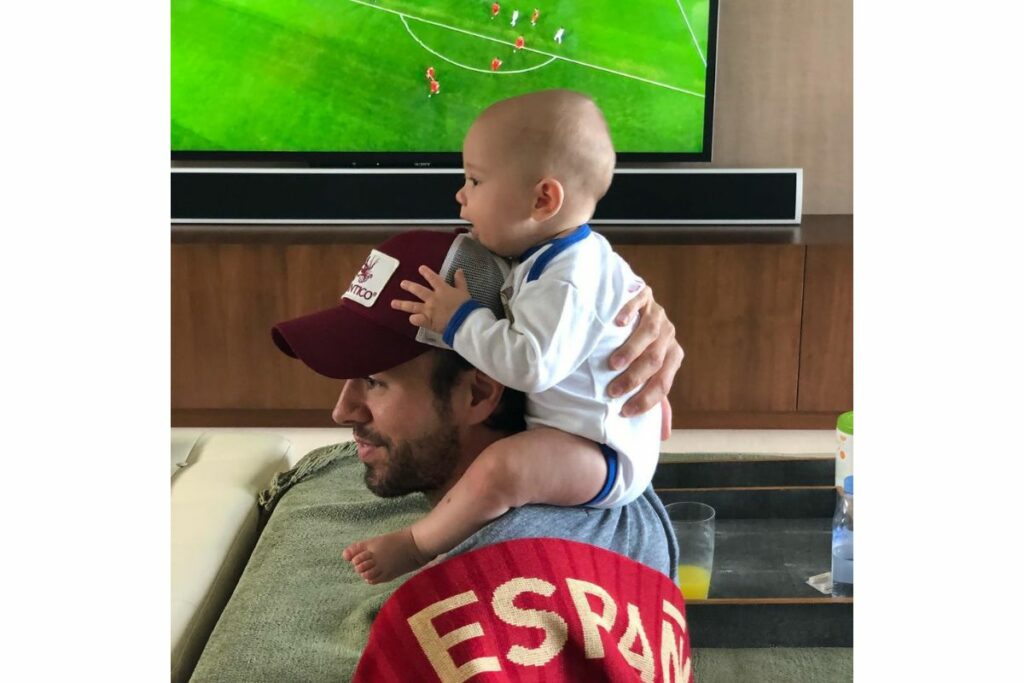 Enrique Iglesias carga en los hombros a uno de sus bebés.