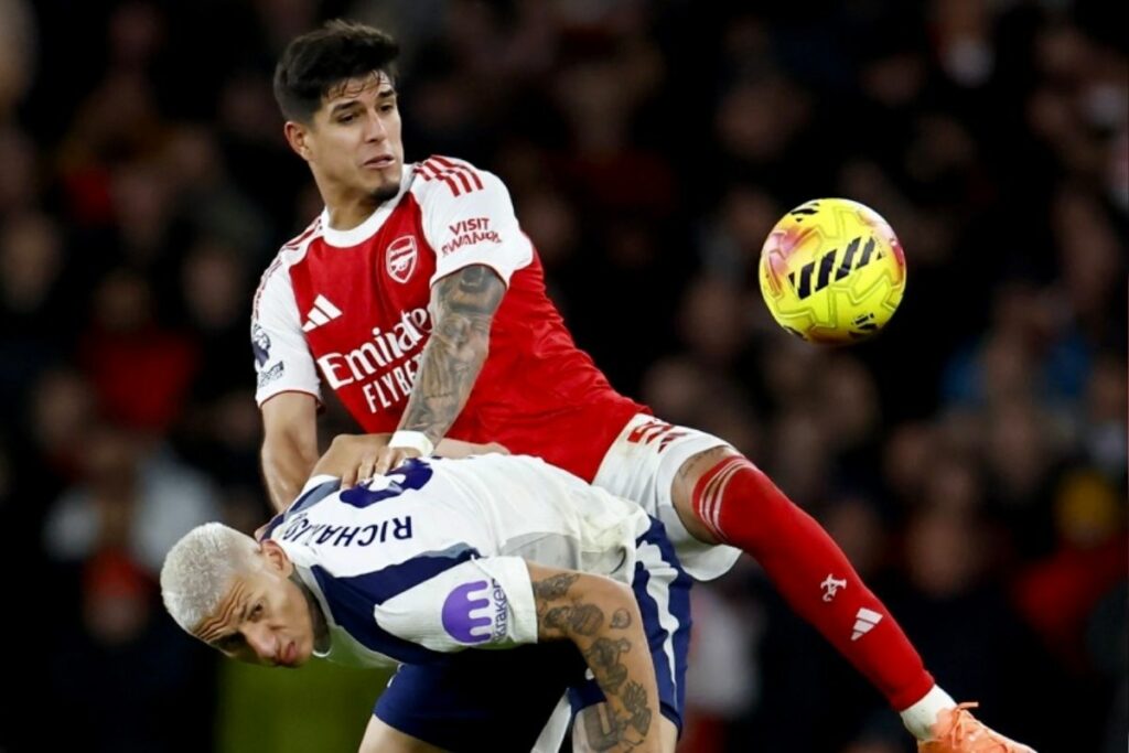 Piero Hincapié (rojo y blanco) dispua un balón con Richarlison antes de jugar con el Arsenal en la Champions League.