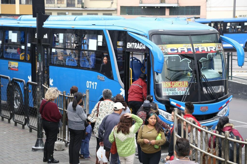 Pasajeros y buses urbanos en Quito durante discusión sobre incremento del pasaje y condiciones del servicio.