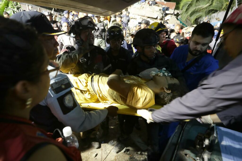 Integrantes de cuerpos de emergencia rescatan a una persona este miércoles, luego de dos fuertes terremotos que sacudieron el Caribe venezolano en Caracas (Venezuela).