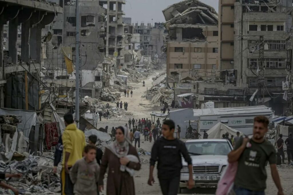 Personas desplazados se mueven por las calles del barrio de Al Shejaeya, en el este de la ciudad de Gaza