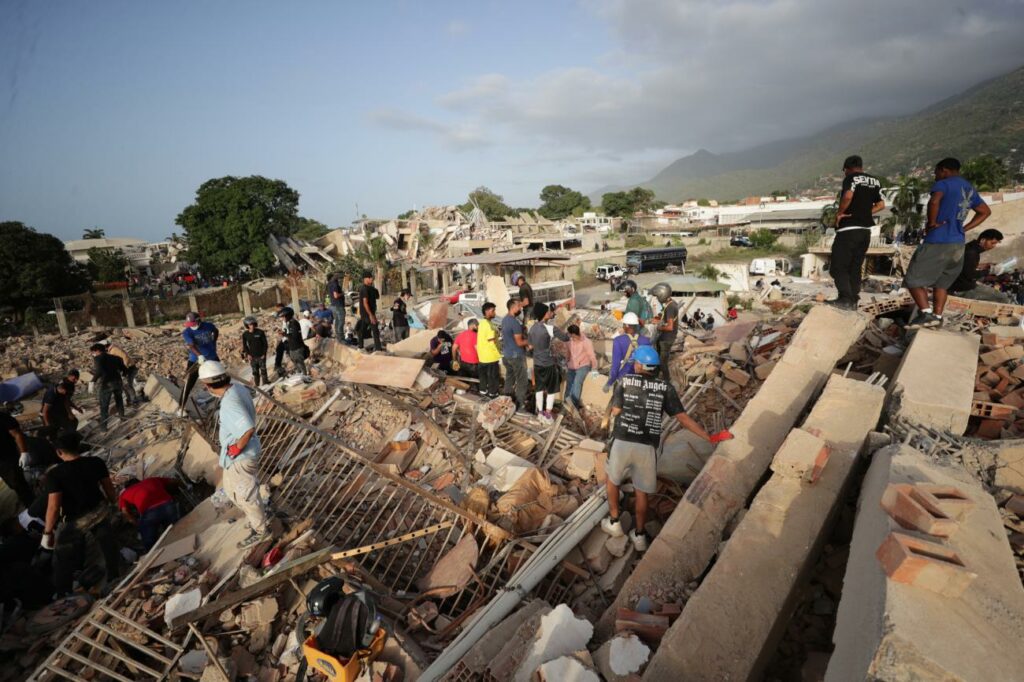 Personas realizan labores de búsqueda en una zona afectada por un terremoto, este viernes en La Guaira, Venezuela.