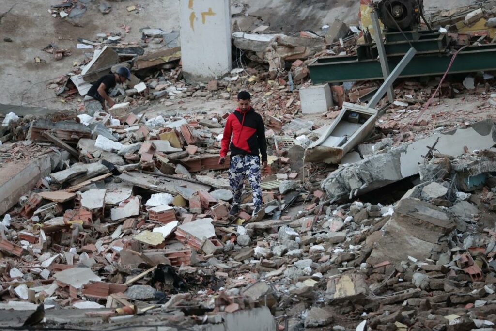 Un residente camina entre los escombros de edificios derrumbados por los terremotos, en la localidad de Catia La Mar, en el estado costero de La Guaira (Venezuela).