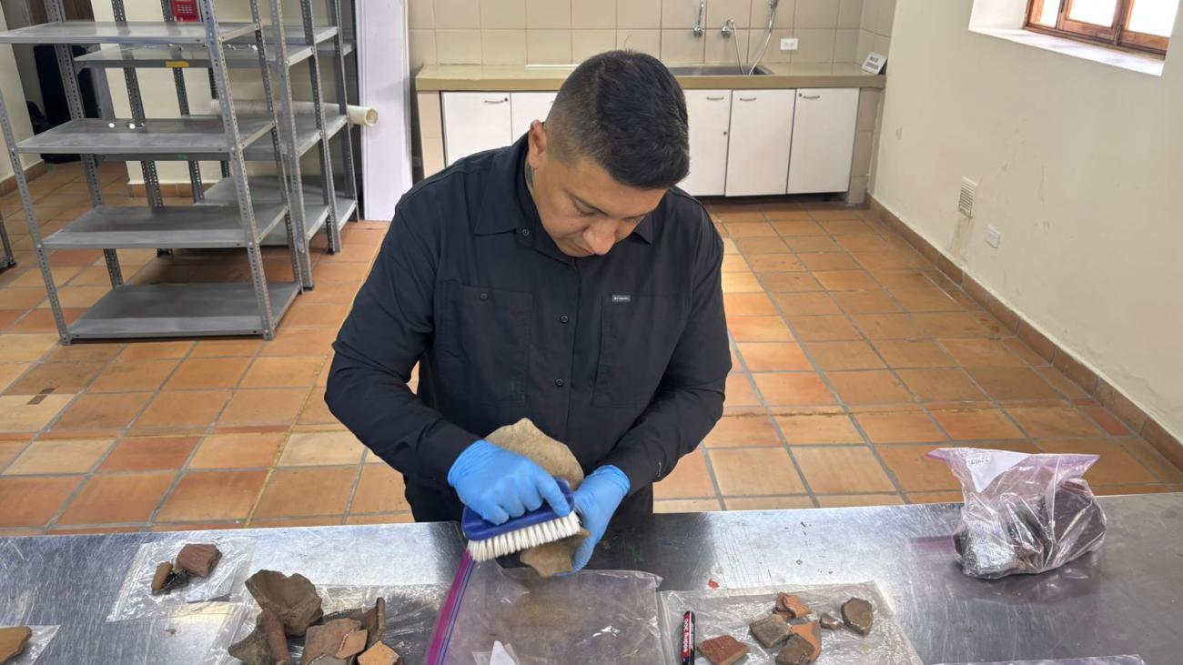 Un arqueólogo limpia cuidadosamente las vasijas descubiertas