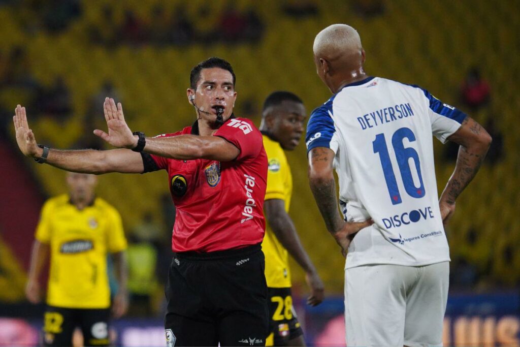 Gabriel González (izq.), árbitro de Barcelona SC vs. Liga de Quito, junto al delantero Deyrverson de la ‘U’.