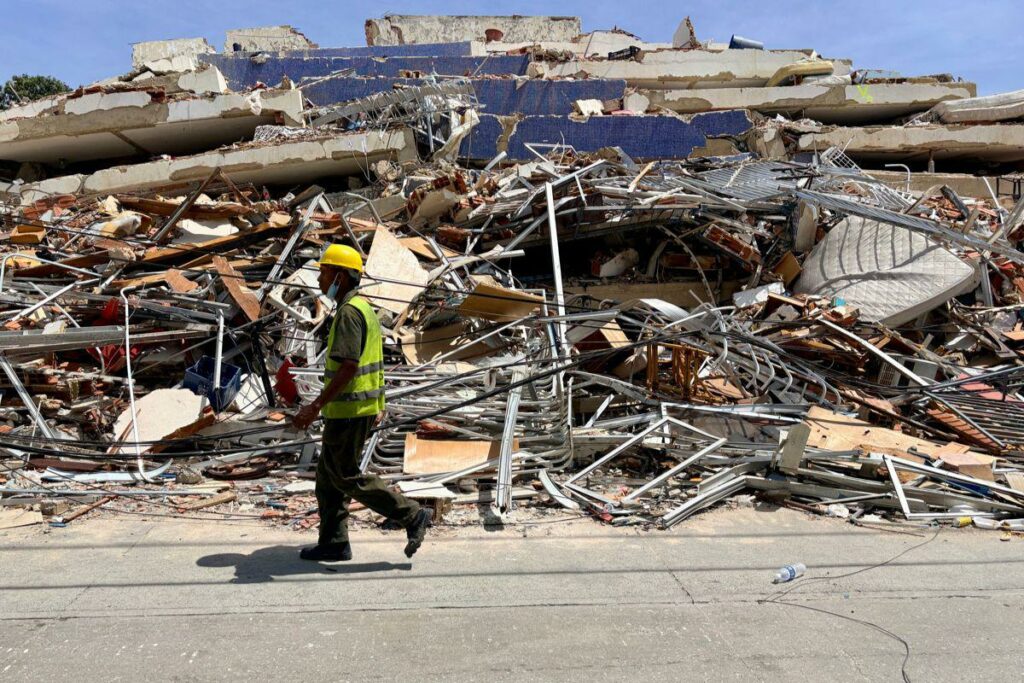 Un hombre camina frente a escombros de una edificación derrumbada por terremotos este jueves, en La Guaira (Venezuela).