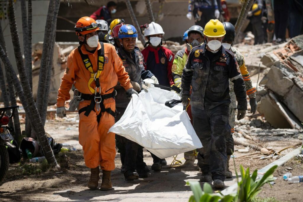 Rescatistas recuperan un cuerpo de los escombros de un edificio afectado por los terremotos en La Guaira (Venezuela).