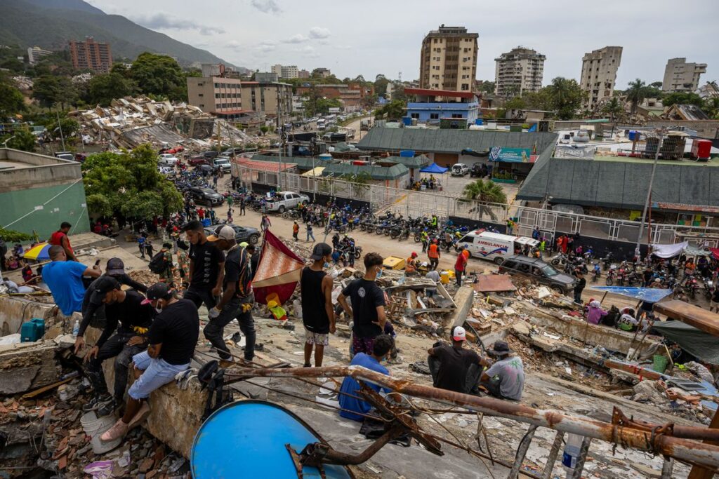Personas observan edificios colapsados por los terremotos este martes, en La Guaira (Venezuela).