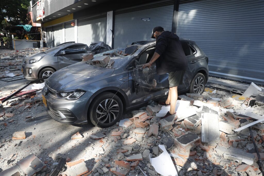 Un hombre observa un vehículo afectado tras un fuerte temblor este lunes, en Cali (Colombia). Un temblor de magnitud 7,4 sacudió gran parte de Colombia este lunes 10 de agosto de 2026.